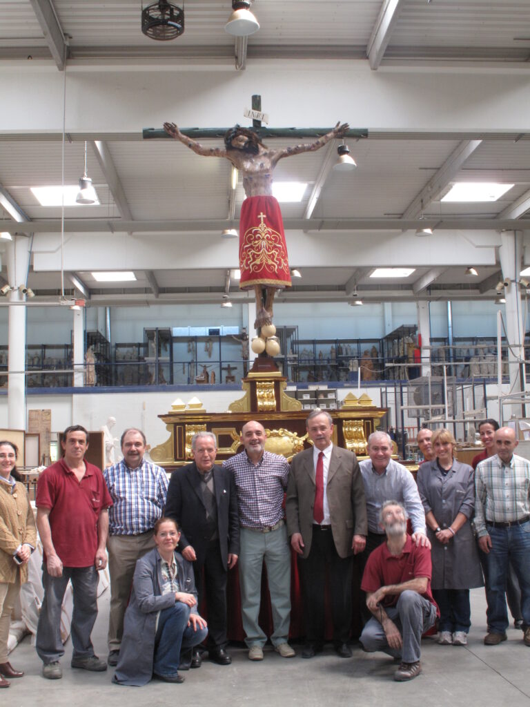 Miembros de Talleres de Arte "Granda" y de la Hermandad del Santo Cristo, posan para una foto tras concluir los trabajos de réplica de la imagen.